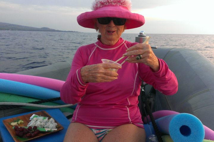 a person wearing a hat and holding a fish in the water